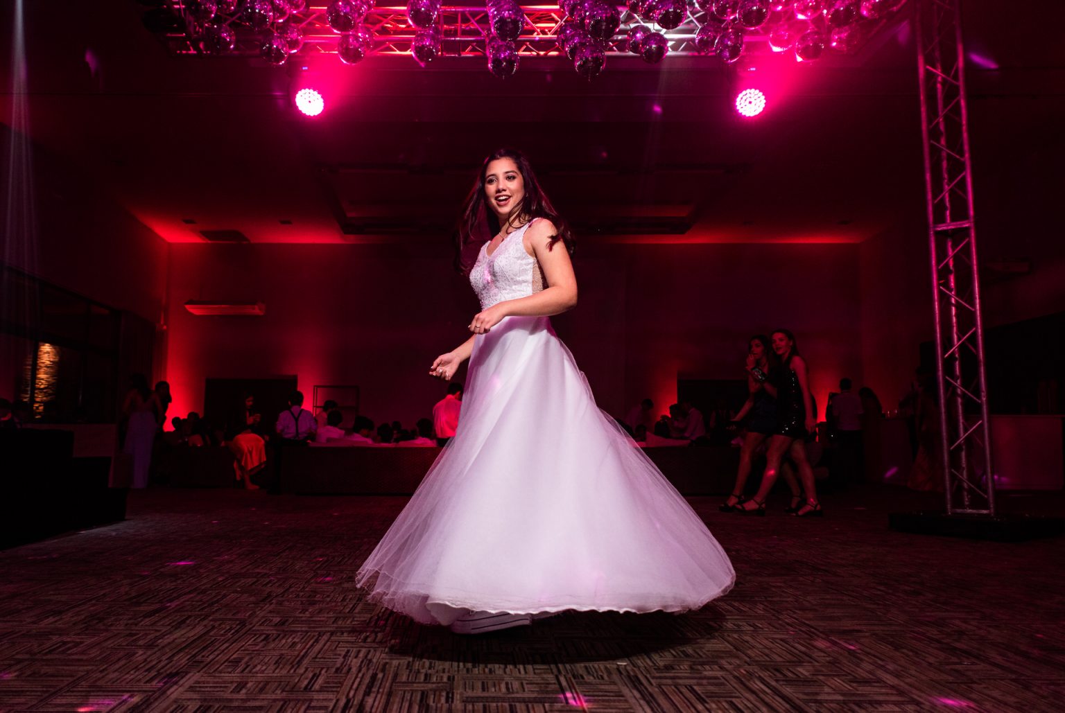 La quinceañera girando con su vestido en la fiesta