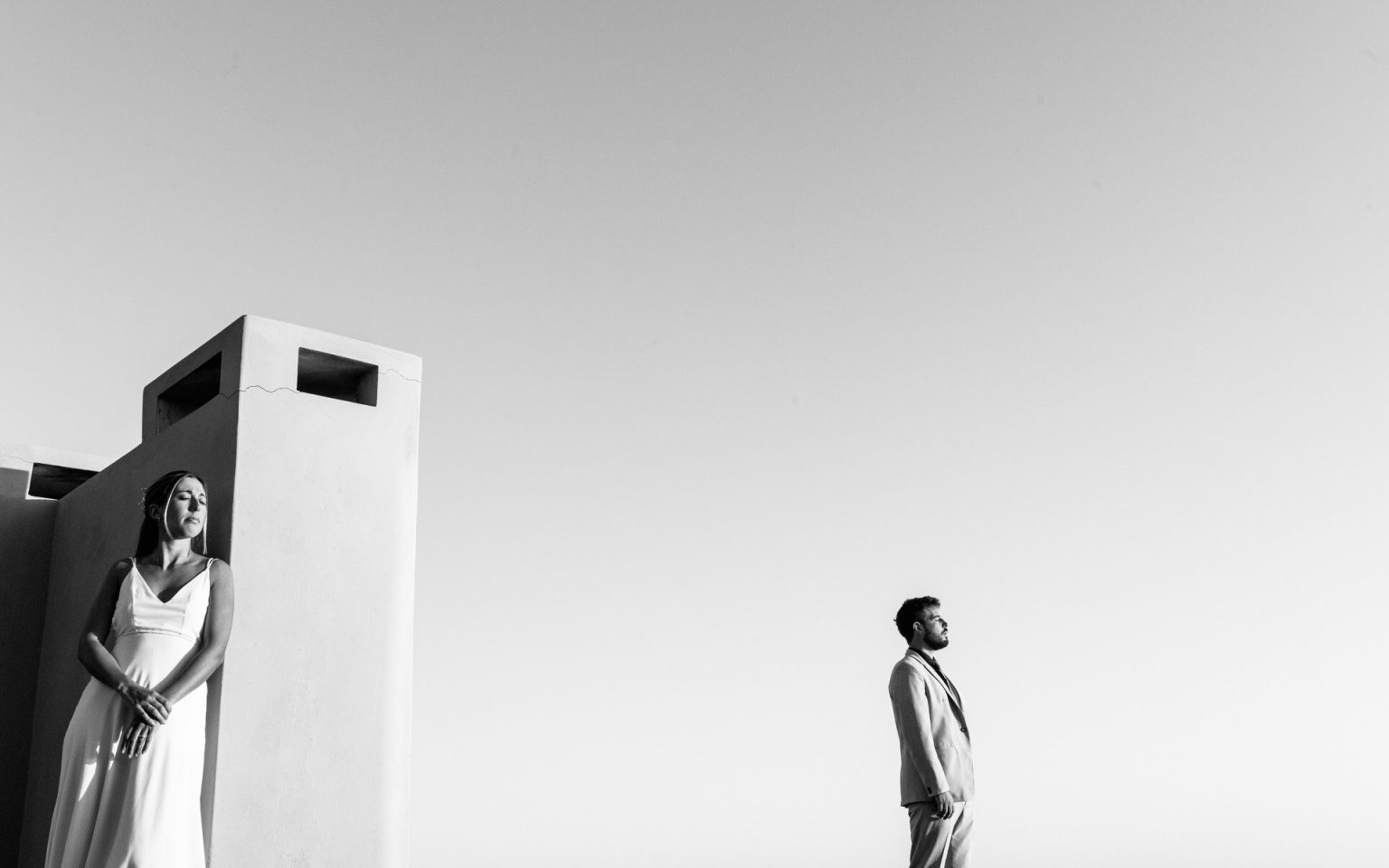 Los novios en una terraza blanca frente al cielo de Punta del Este, en blanco y negro