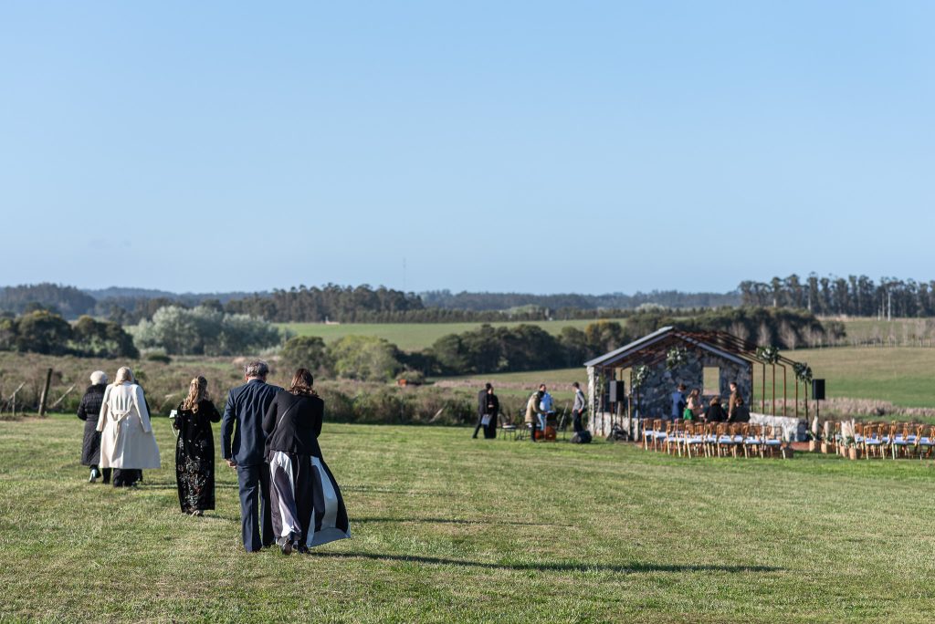 Invitados caminando por el campo hacia la ceremonia, boda en Narbona, Punta del Este