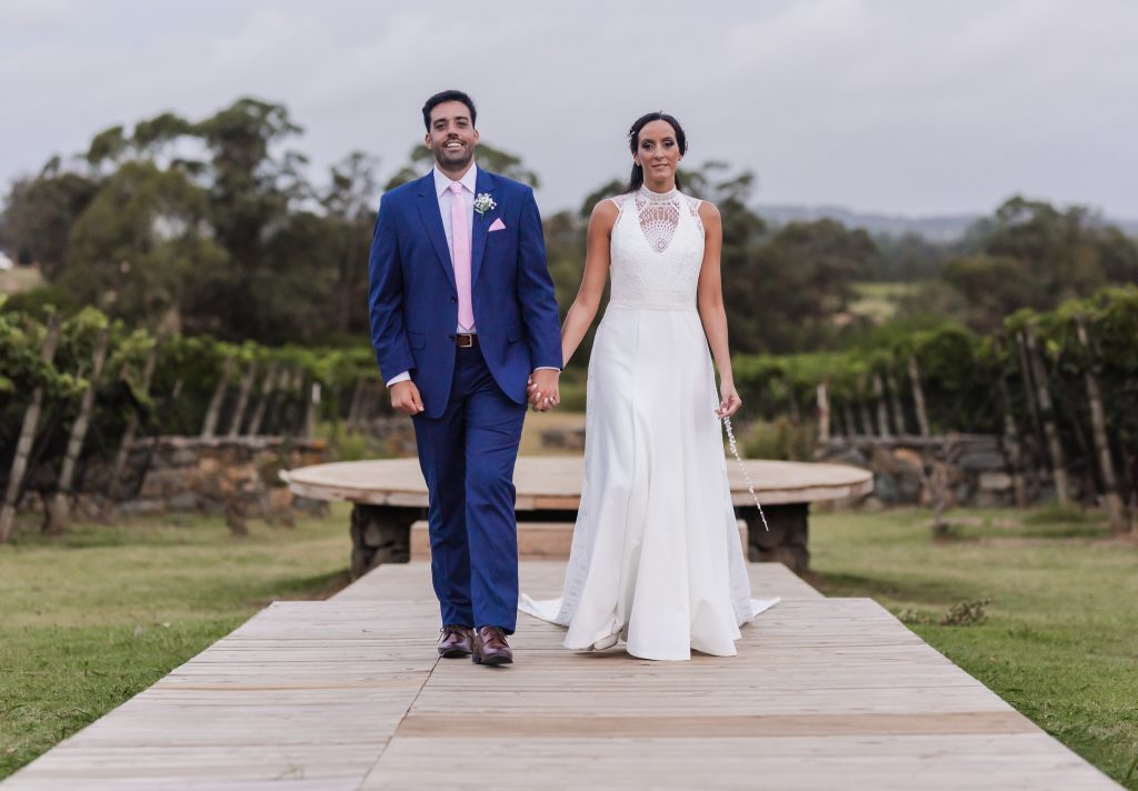 The couple walking hand in hand among the vineyards at Aguaverde, Uruguay