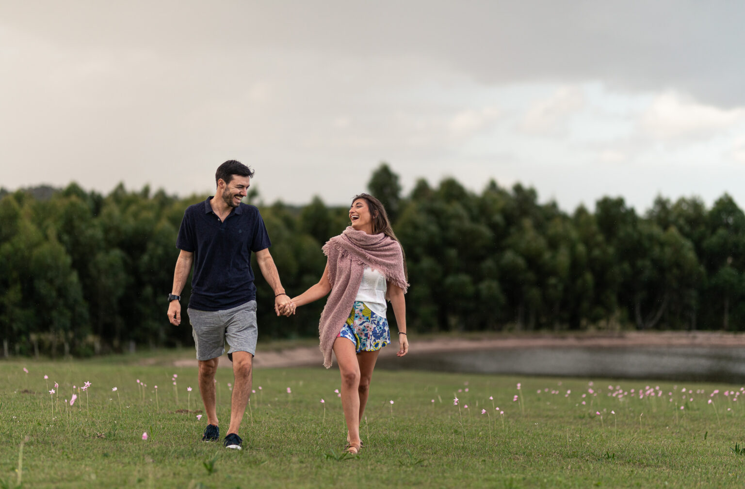 Pareja caminando de la mano por el campo