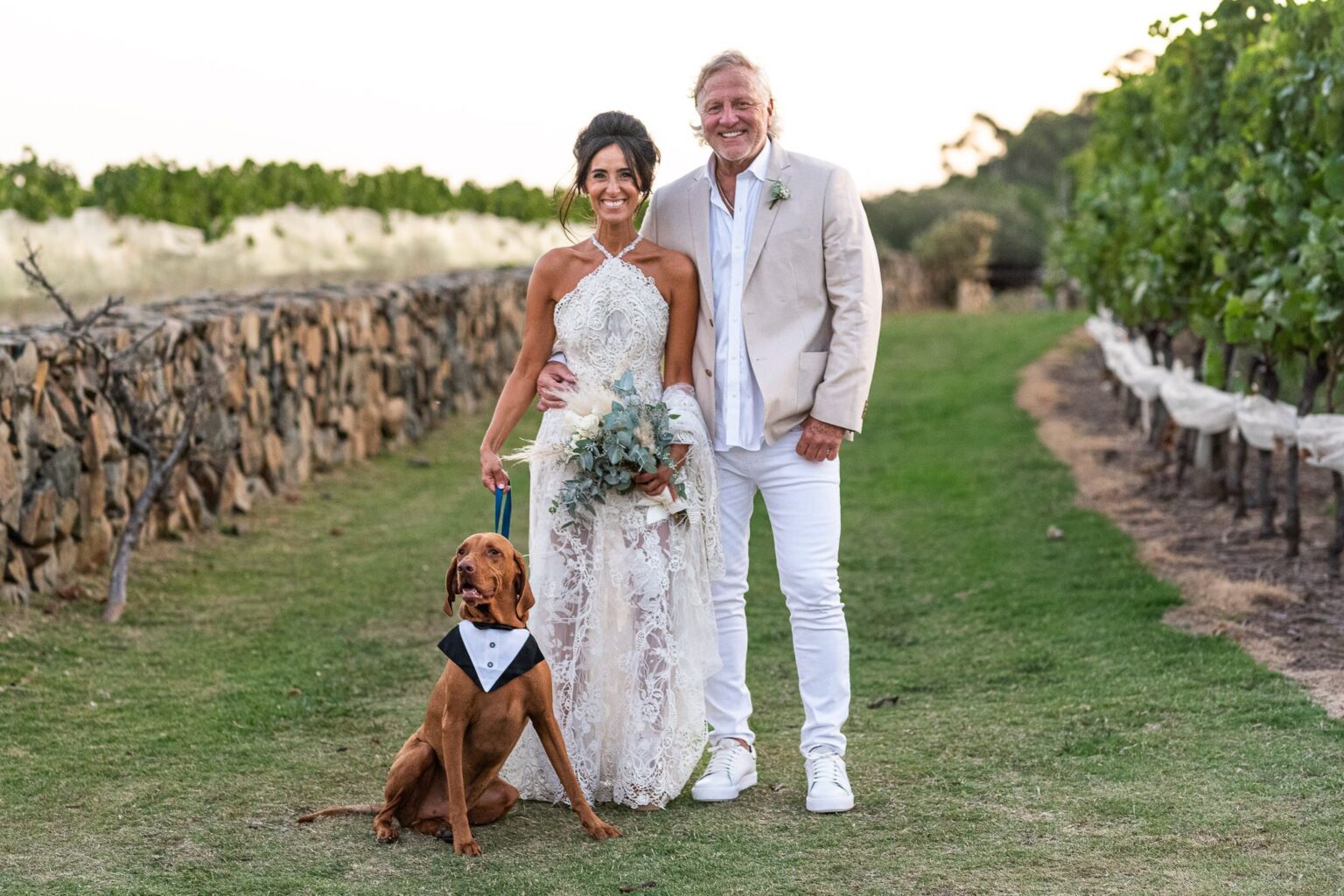Los novios con su perro entre los viñedos