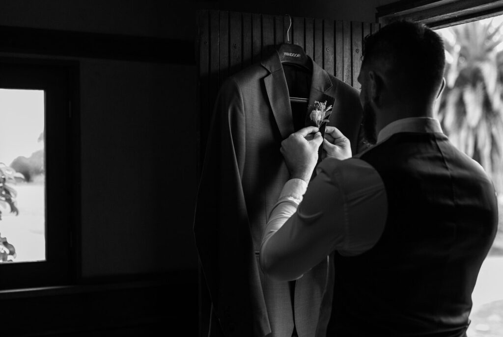 El novio preparándose frente a la ventana, en blanco y negro